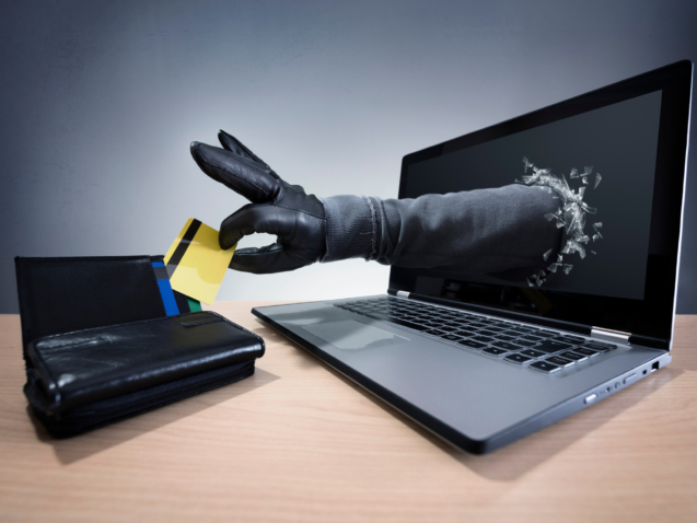 Stealing a credit card through a laptop concept for computer hacker, network security and electronic banking security